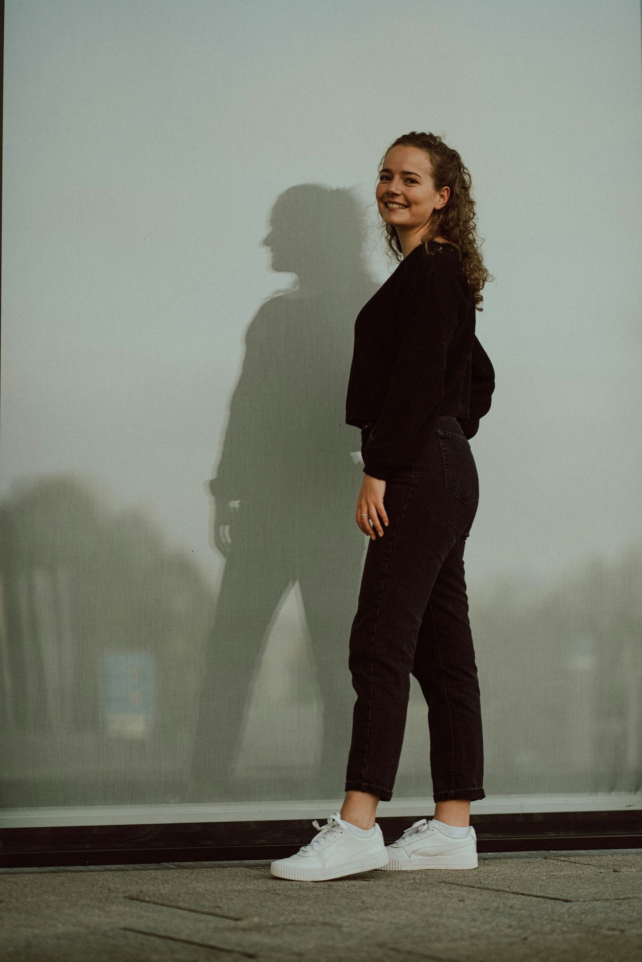 a woman standing in front of a large picture